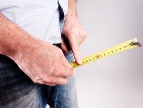 a man measuring his penis before lifting with soda